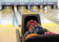 Boule colorée dans le porte-boules allée de bowling derrière