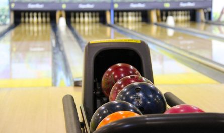 Boule colorée dans le porte-boules allée de bowling derrière
