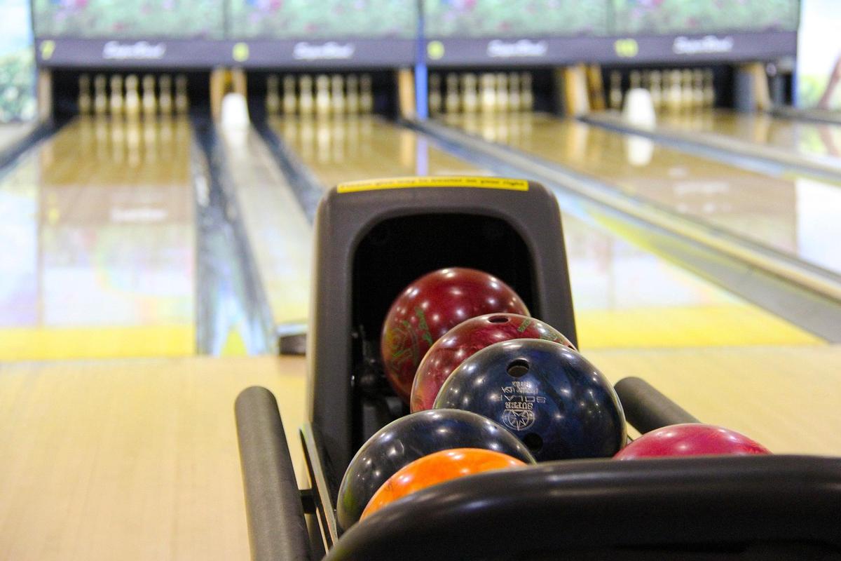 Boule colorée dans le porte-boules allée de bowling derrière