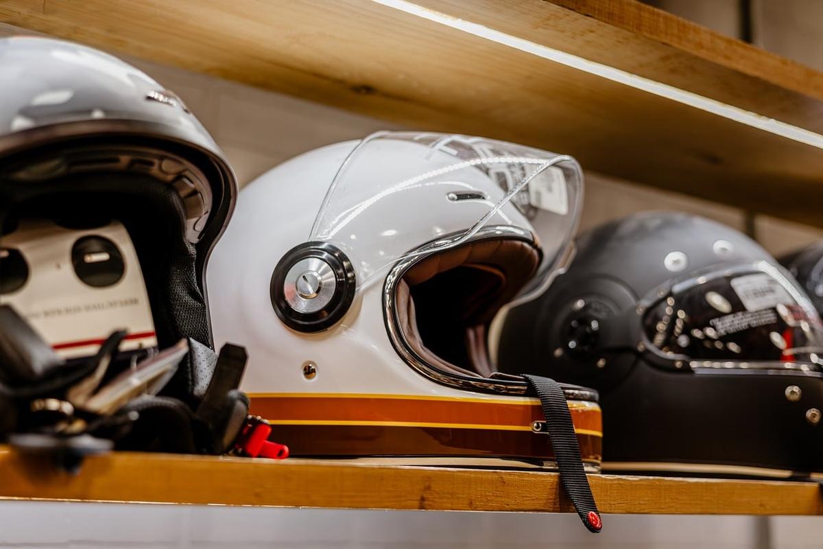 Casques de moto vintage rangés sur une étagère en bois